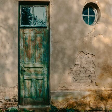 A weathered green door on an aged wall in Lviv, Ukraine, showcasing rustic charm and historic architecture.